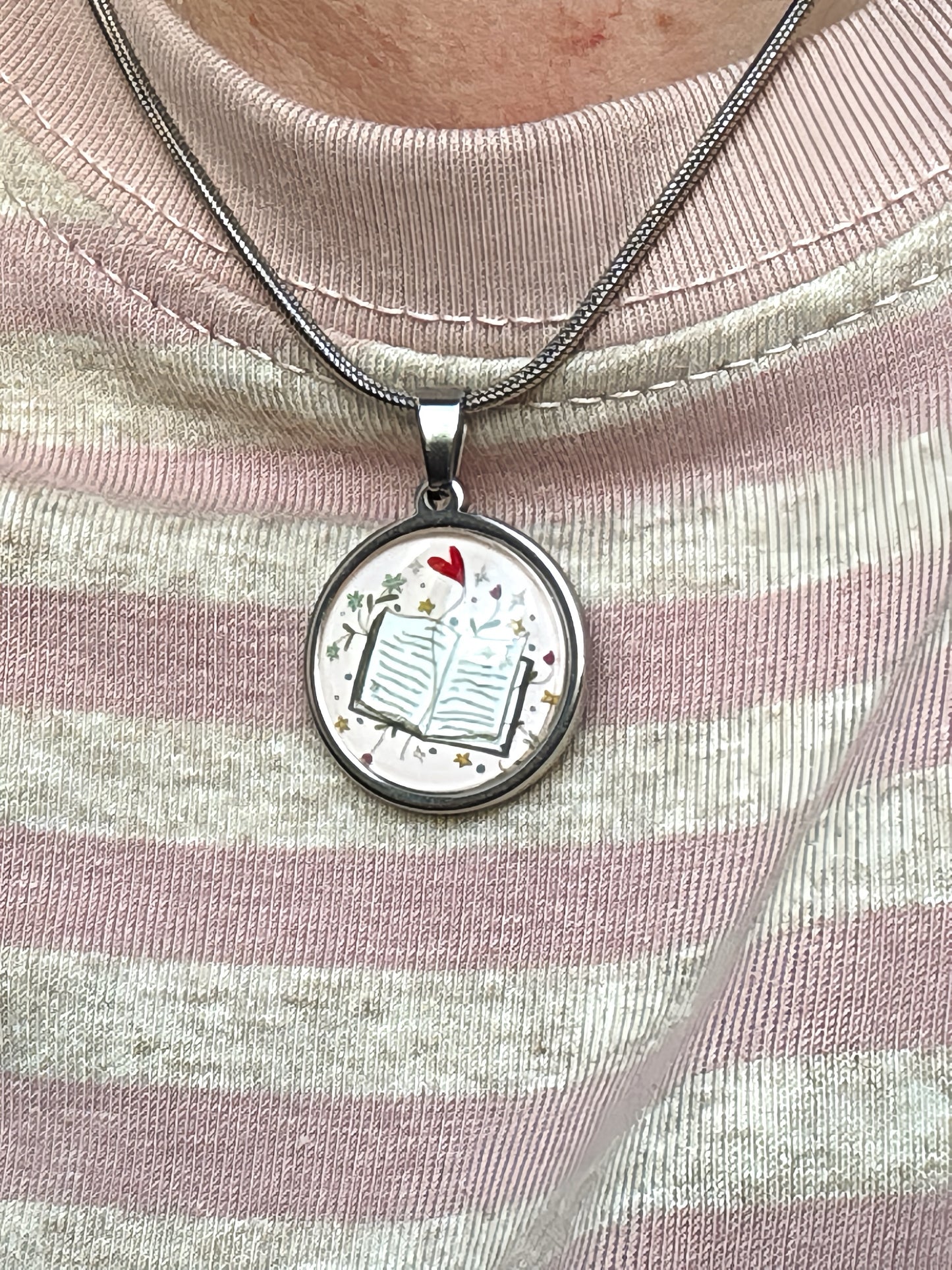 Ciondolo “Leggere fa bene al cuore” in acciaio