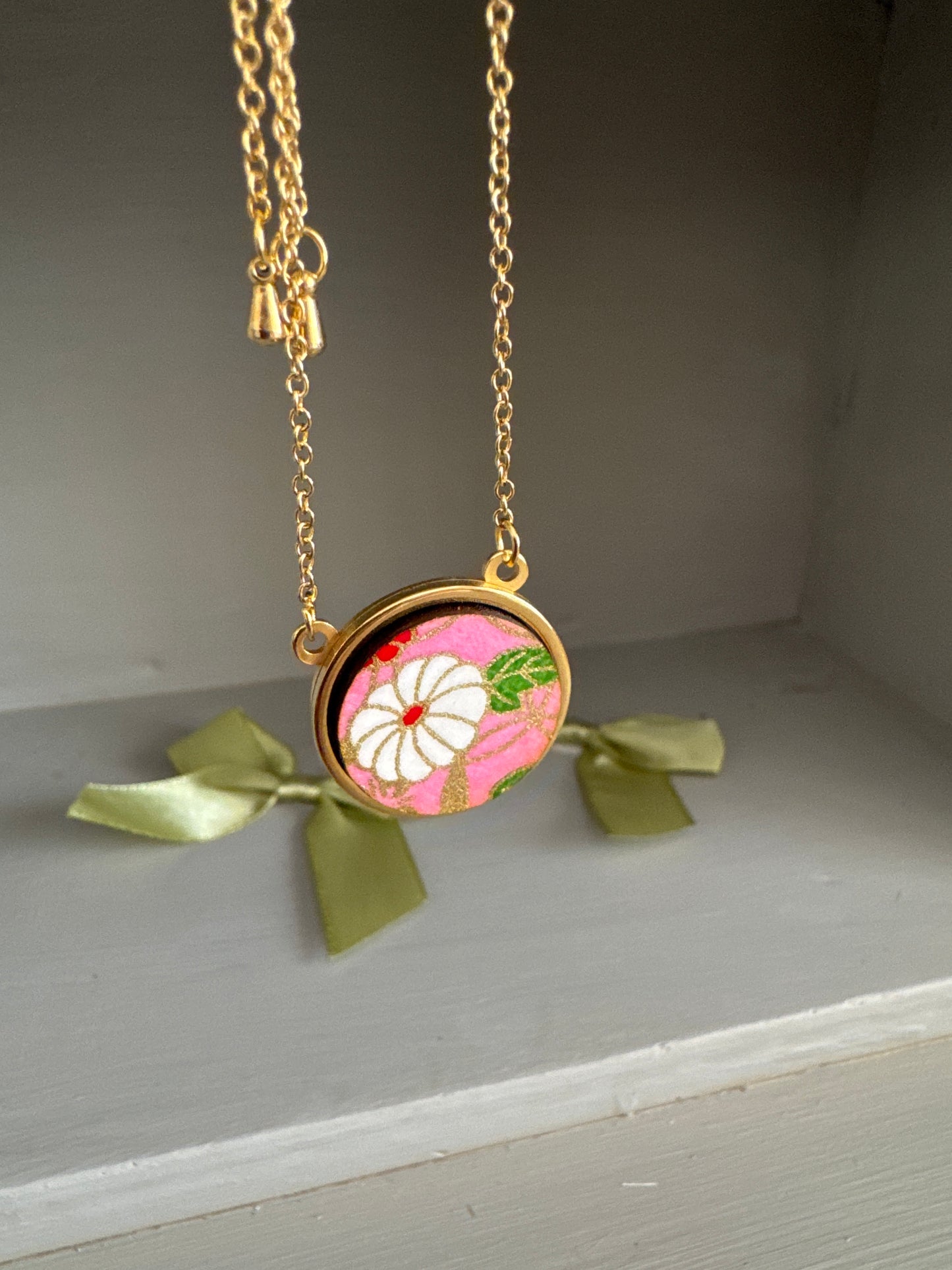 Collana regolabile con ciondolo floreale su fondo rosa