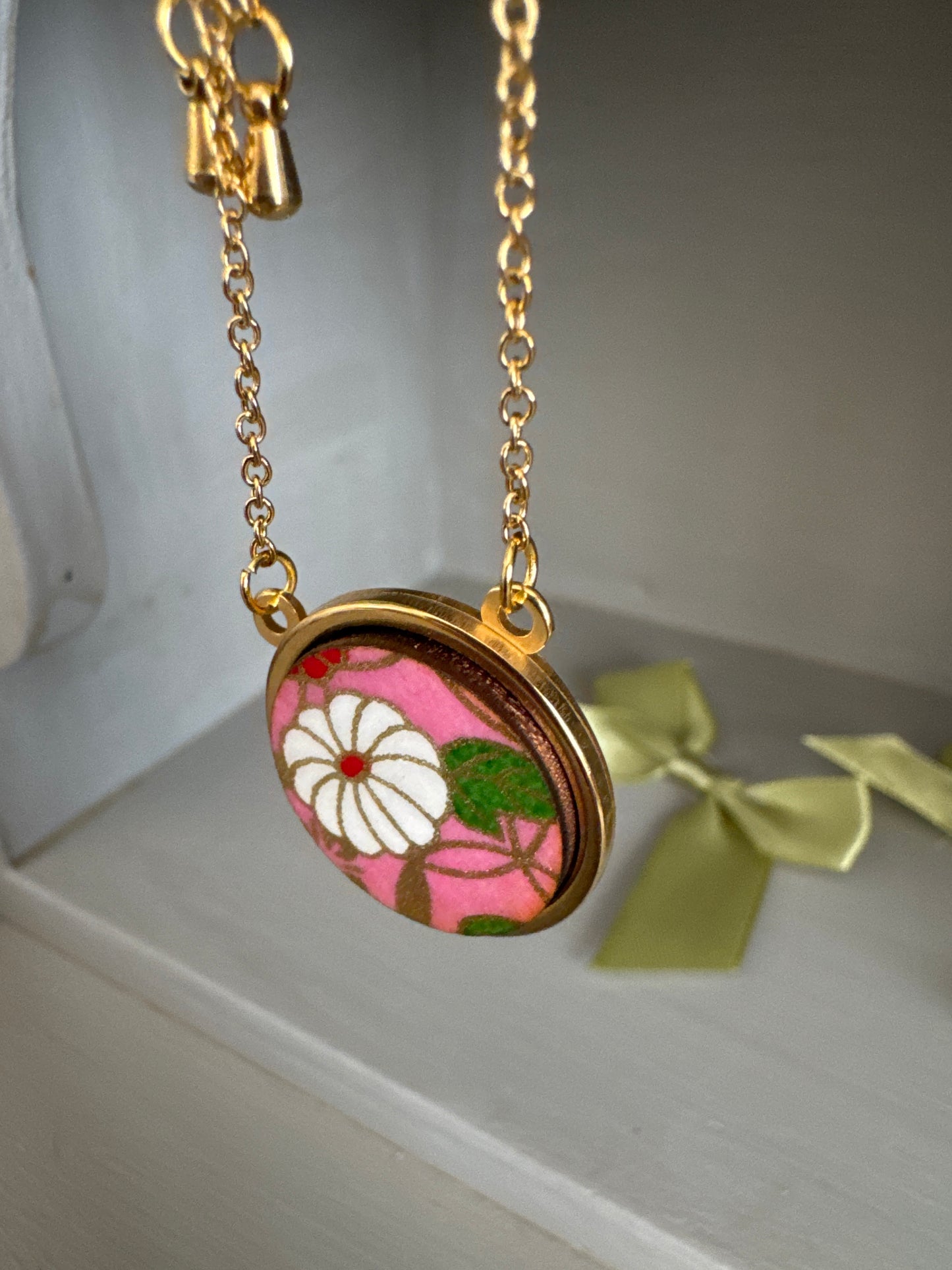 Collana regolabile con ciondolo floreale su fondo rosa